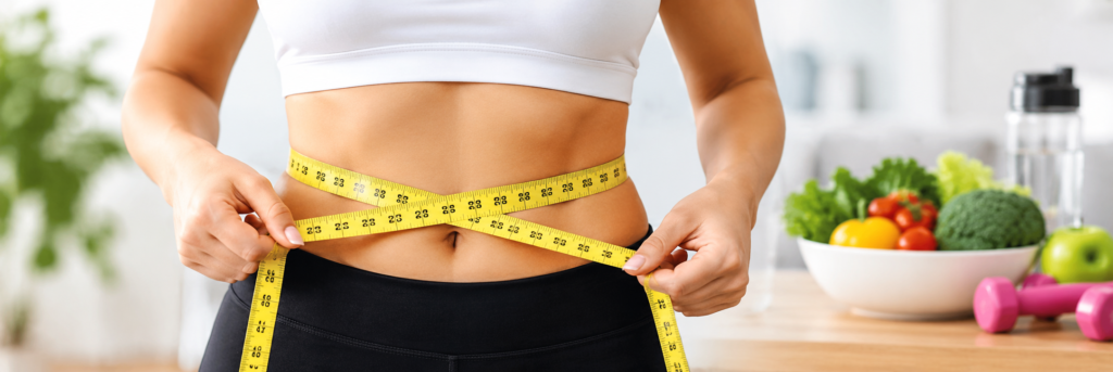 Woman measuring her waist with a measuring tape for weight loss