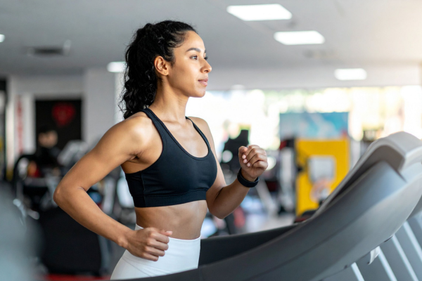 Woman running on a treadmill during a gym workout